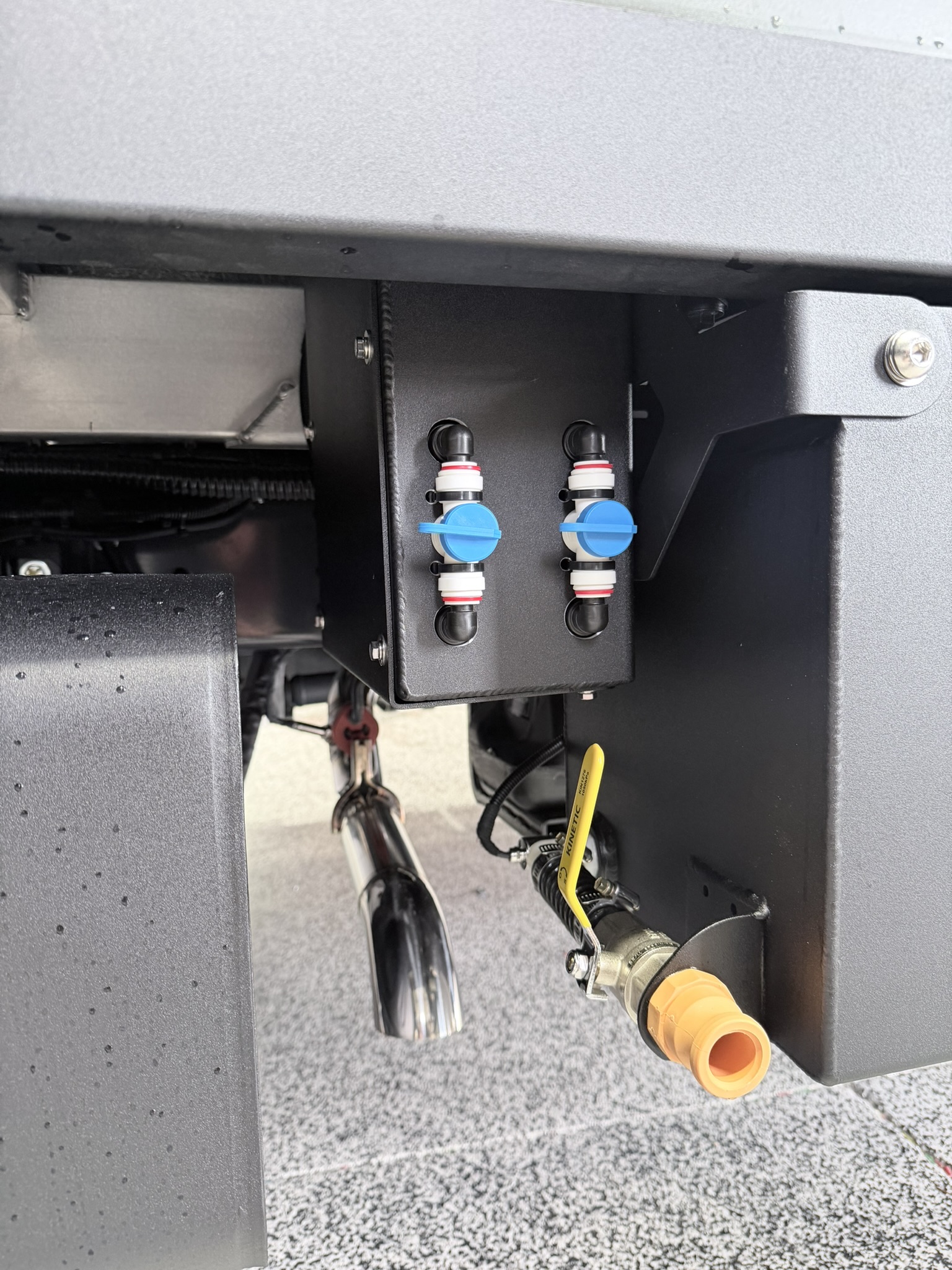 Twin self-draining quick-connect water valves mounted under the habitat