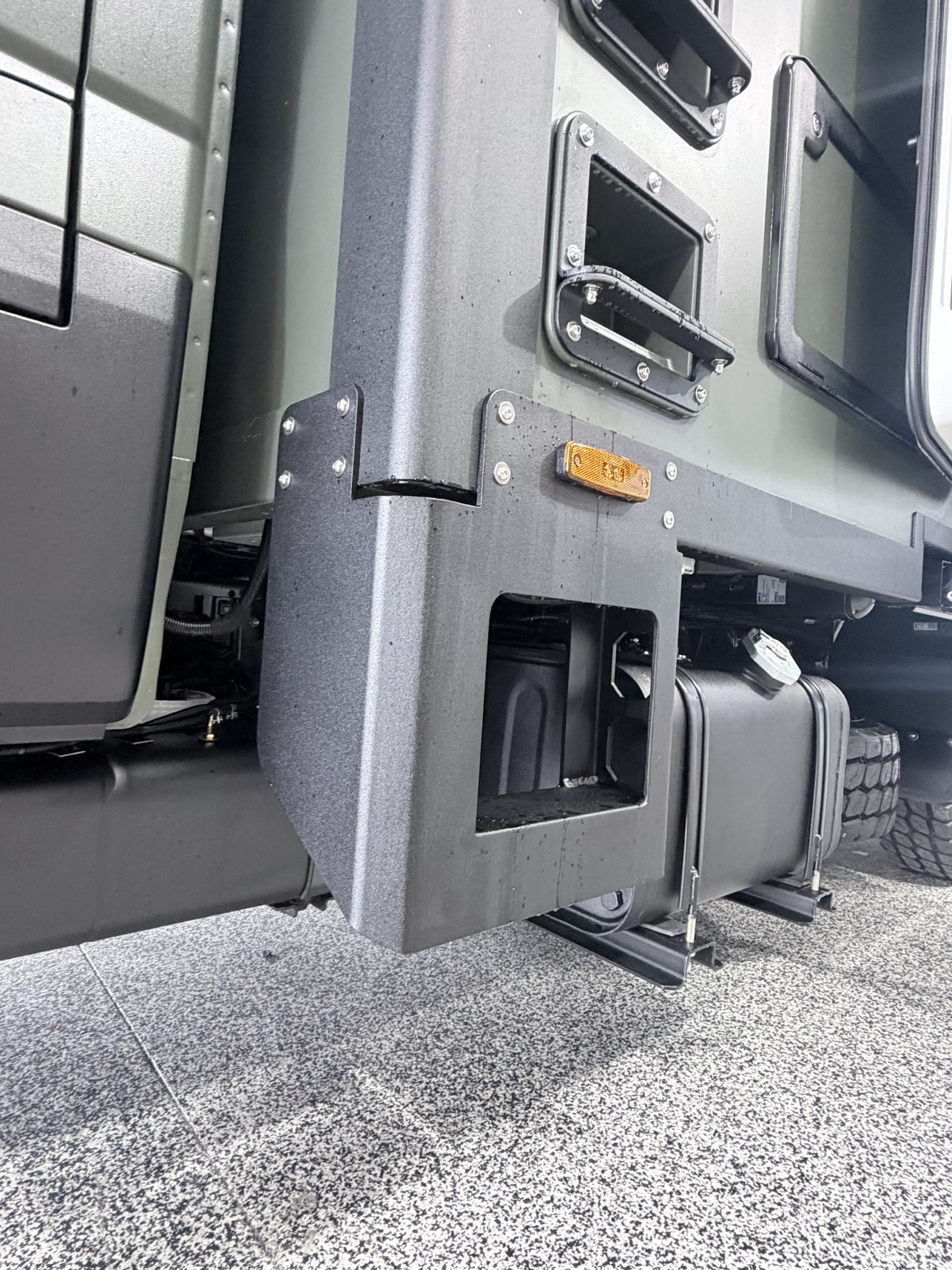 Close-up of the articulating body mount joint between cab and habitat, with auxiliary fuel tanks visible below